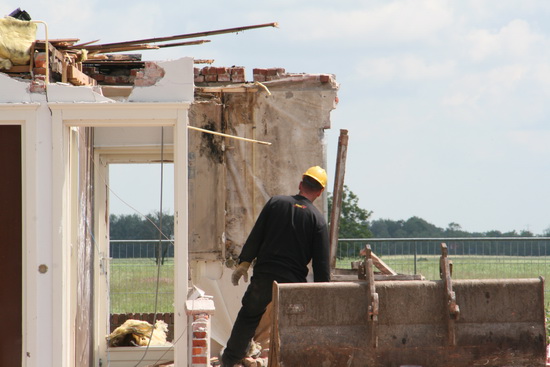 De geelgehelmde BORKwerknemer kijkt even of er nog complicerende factoren in het achterhuis zijn...  Nee? Doorgaan maar!