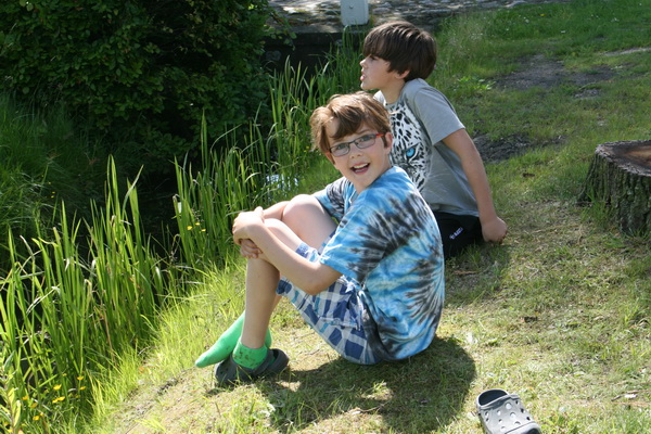 Enkele jeugdige nieuwsgierigen hebben een zonnig plekje bemachtigt. Schoolvrij, jongens? 