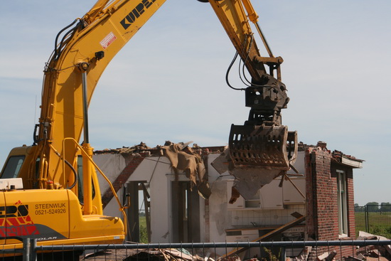 Het puntdak van Langestraat 9 is al afgebroken, als ik in de loop van de morgen aankom bij de sloopplek. De verse machinist zet er vaart achter....