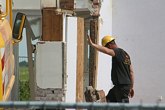 De gele BORKer kijkt, ziét en waarschuwt: STOP! De kraanmachinist zet de machine stil, komt zelf ook voorzichtig kijken...