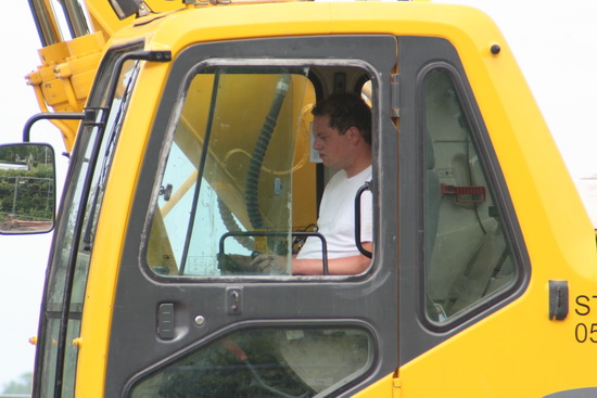 De witte BORKer in zijn cabine... Of noemen ze het 'cockpit'?  Heeft nu de gelegenheid de stapels hout en rommel, gescheiden, in de daartoe bestemde containers te kieperen...