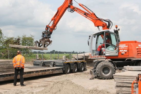 Op  de open ruimte van Langestraat 11 en 9 worden grote betonnen platen gelost.