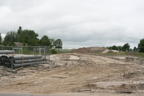 Aan de overkant, op het terrein waar de nieuwe rotonde en nieuwe weg voor het lokale verkeer komen, schittert Oosterhof Holman al de hele week door afwezigheid. Of moet het zand langer liggen? (Als het maar blijft liggen en niet verstuift...)