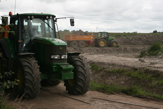 De stoere John Deeres met kiepkarren rijden af en aan. Grond brengen, grond halen, het heeft wel iets van een werkgelegenheidsproject.....