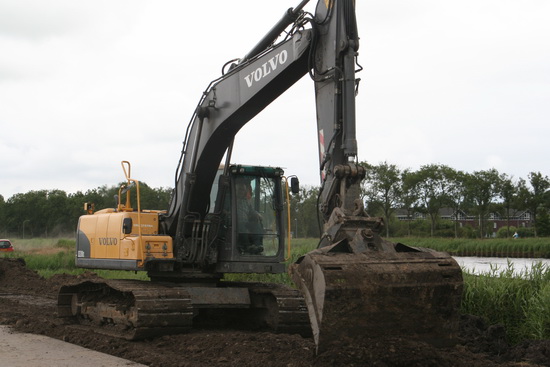 Een van de gravers die constant bezig is tussen nieuwe weg en kanaal. Graven en vereffenen, schrapen en weer graven....