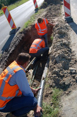 De oude buis wordt afgezaagd.