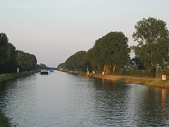 Op het Van Starkenborghkanaal is het nog steeds druk. Rechts is een verbreding zichtbaar, daar wordt ook bagger opgediept en oostwaarts vervoerd. Verderop bij de kraan de plek waar de nieuwe hoge brug komt.