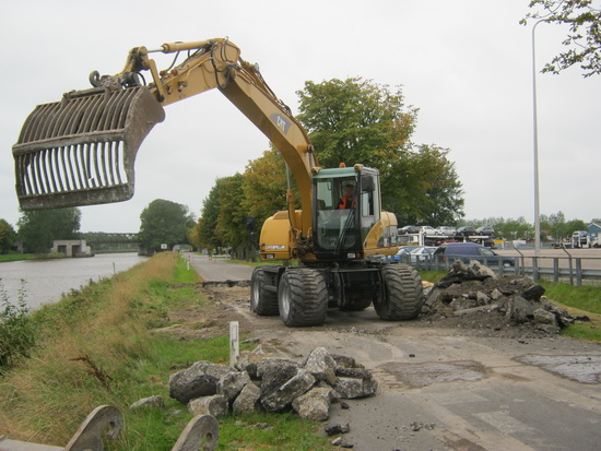 Als we 's middags een wandeling maken, zien we langs het Van Starkenborghkanaal NZ ter hoogte van het Koopman-parkeerterrein onverwachte wegwerkzaamheid. De weg is afgesloten, een grijper haalt het asfaltwegdek deels weg. Forse brokken...