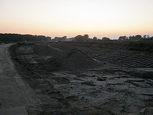 Eigenlijk al te donker voor het maken van landschapsfoto's... De situatie bij de bochtverruiming, voorbij de spoorbrug. Er zijn reuzevorderingen gemaakt. Een gelukszoeker is met zijn metaaldetector in de avondschemer bezig iets van waarde uit de omgerommelde aarde te halen...