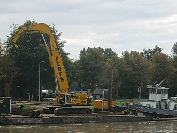 Hoe noem je zo'n vlot? Een ponton? In ieder geval wordt het drijvende werkeiland keurig op zijn plaats gelegd door "Hendrik", de duwboot uit Drachten.