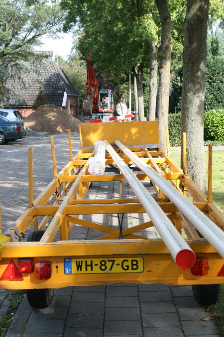 Een wagen met kunststof buizen, langs de Noordwijkweg geparkeerd. Iets verderop de hoek van de Norritsstraat, waar de boel op de kop staat....