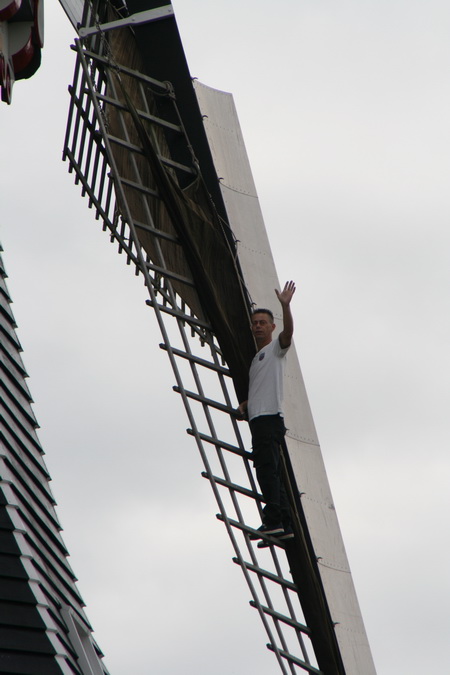 Kandidaat-molenaar André Bood op een van de wieken, wuivend. Hoort ook bij de opleiding. "Nee, André, niet met losse handen...."