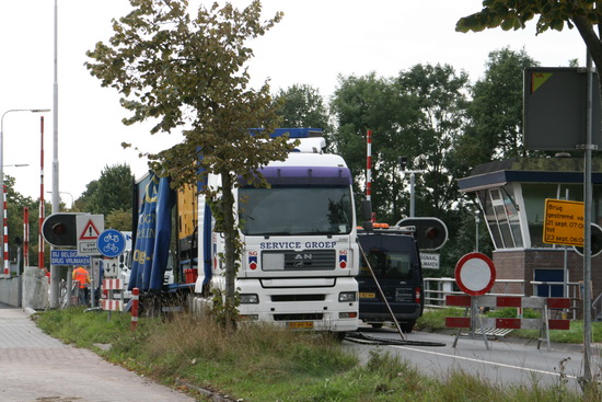 Bij de gestremde brug is het eend rukte van belang. Aan weeerskanten vrachtwagens met materialen, hulpmiddelen etc.  Voor snelverkeer geen doorkomen aan.... Fietsers en voetgangers passeren als vanouds. Zij wachten alleen maar als er een schip passeert en de brug omhoog gaat....