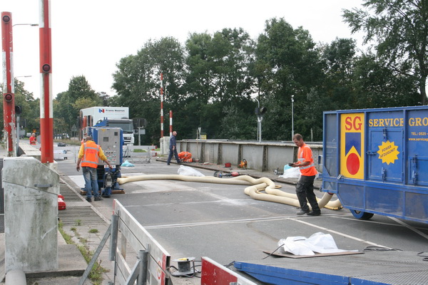 Op het rijbaangedeelte van de brug wordt intensief gewerkt. De brug is niet omhoog, de fietsers en voetgangers hoeven niet te klimmen of te klauteren, niet te dalen of te glijden...
