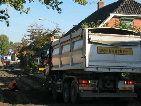 Een zwaarbeladen vrachtauto van Van der Wiel heeft moeite vaste grond onder de wielen te krijgen.... Uiteindelijk lukt het en kan de auto richting Langestraat Noord.