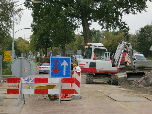 Aan de kop van de parallelweg is ook weinig ruimte beschikbaar voor het verkeer. Achter het hekwerk zit een werknemer letterlijk in de put....