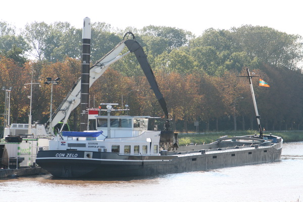 Riskante fotografie, zon van voren... Diffuus licht bij, al weer, de "Con Zelo", de grondvervoerder die zijn maagvulling ontvangt van de baggeraars van Martens en Van Oord op het werkeiland. Bij de sleuf waar de gasbuis wordt verzonken, komend weekeinde.