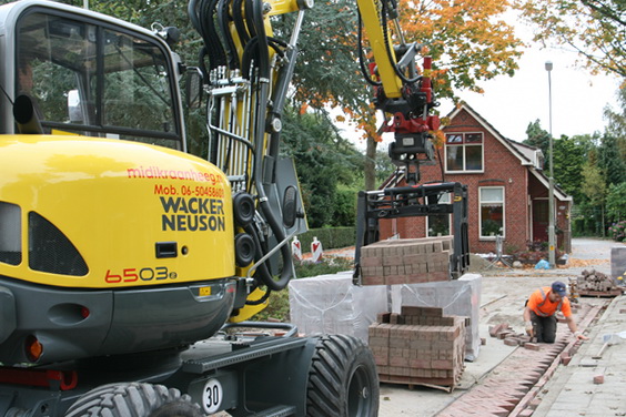 Zo gaat het dus... Stenen liften, naar voren zwaaien en op de straatbrede legmachine plaatsen. Moderne apparatuur, snel handelen...