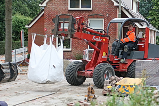 Kijk, een grote zak met afgekeurde steenproducten wordt afgevoerd door een enthousiaste "Manusje-van-alles"...