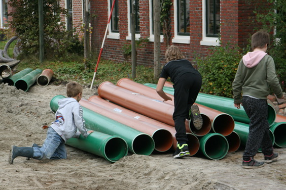 Aan de rand van het rioleringsgebeuren spelen kinderen op de vrije woensdagmiddag met het aanwezige materiaal: zand en buizen!