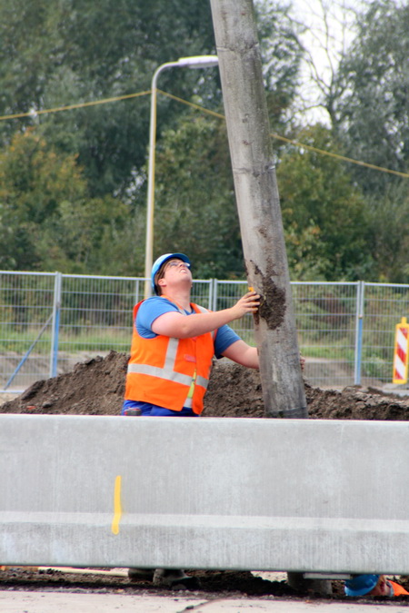 Voor dit werk moet je zeker iets onder de helm, maar ook in de armen hebben. "Tsjonge, toch een grote jongen, zo'n paal!"