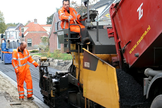 En deze KWS-werkers kijken naar de richtsnoer, zodat er een puike, rechte asfaltlaag komt te liggen!