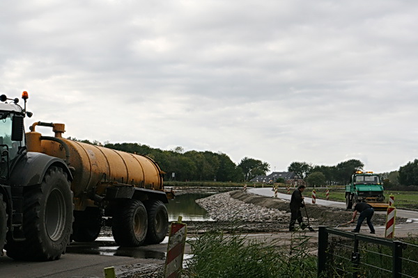 Zo is het beter te zien. Een tweetal reinigers met een tankwagen en een veegmachine, en met een gewone schep met steel.... 