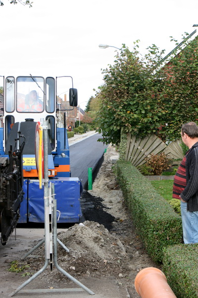 Anne Adema, op de hoek van Noorderweg en Nieuwstraat, ziet dat er een fraaie dubbele laag asfalt is gelegd...