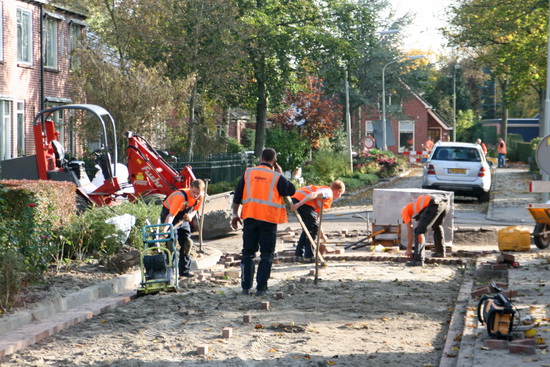 De ploeg stratenmakers die op of bij het kruispunt met de Verlengde Oosterweg bezig zijn in de Norritsstraat. En eentje is altijd aan het bellen....