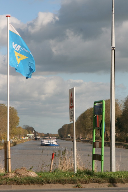 Aan de noordkant van de brug wappert fier de GMB-vlag richting de drukte verderop, waar de nieuwe brug komt! En een grote binnenvaarder nadert....