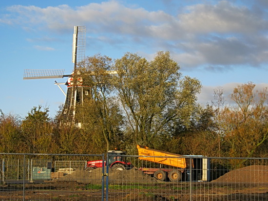 Dan maar even het nieuwe asfaltpad naast de omleidingsweg op gewandeld, nieuwsgierig naar waar het pad eindigt... Aan de overkant rijdt de tractor met kiepkar achteruit richting bulten steenslag. Nieuwe lading halen....