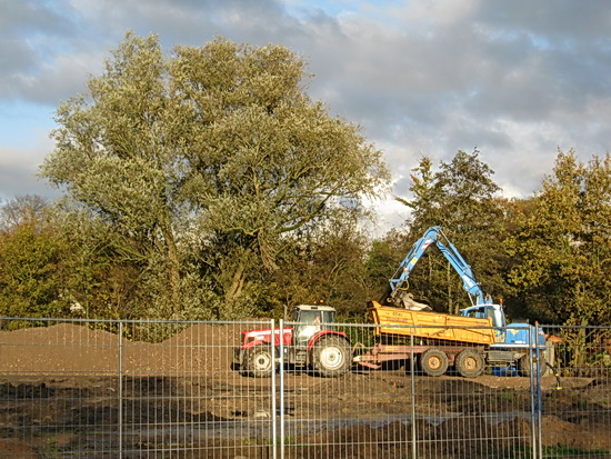 Daar is de bekende GMB-grijper ook al, begint vlot met het vullen van de bak. Steenslag... Gemalen baksteen? Gravel? Of heet het anders? In ieder geval wordt het naar het oostelijke tunnelterrein gebracht, naast de woning van Willem Wieringa. Die kant wordt verhard, maar dat meldde ik gisteren al...
