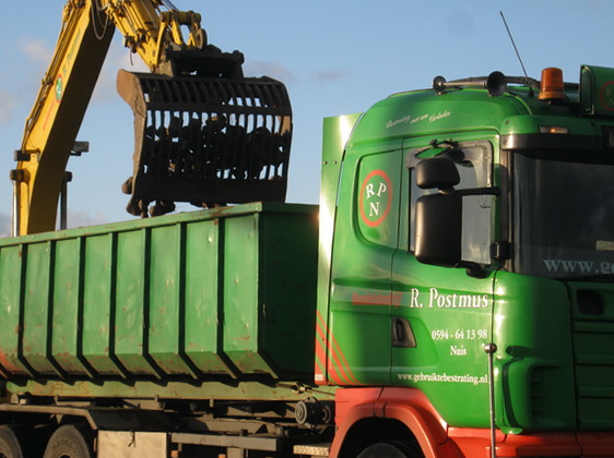 Aan het eind van het nieuwe pad waarop ik loop, staat een Postmus-vrachtauto die wordt geladen met de veldkeitjes die in de ondergrond van de Mokkenburgweg zijn gevonden. Wat zou de bestemming zijn?