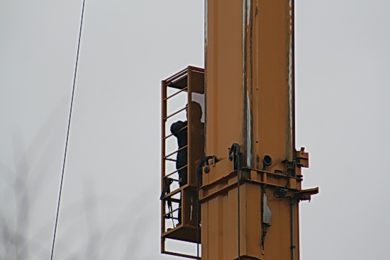 De kraancommandant spoedt zich eveneens naar boven, met de lift. 