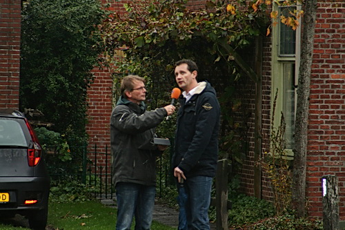 Jan Been houdt ondertussen zijn interview met wethouder Fred Stol, die zichtbaar plezier beleeft aan deze activiteiten in het openbaar.